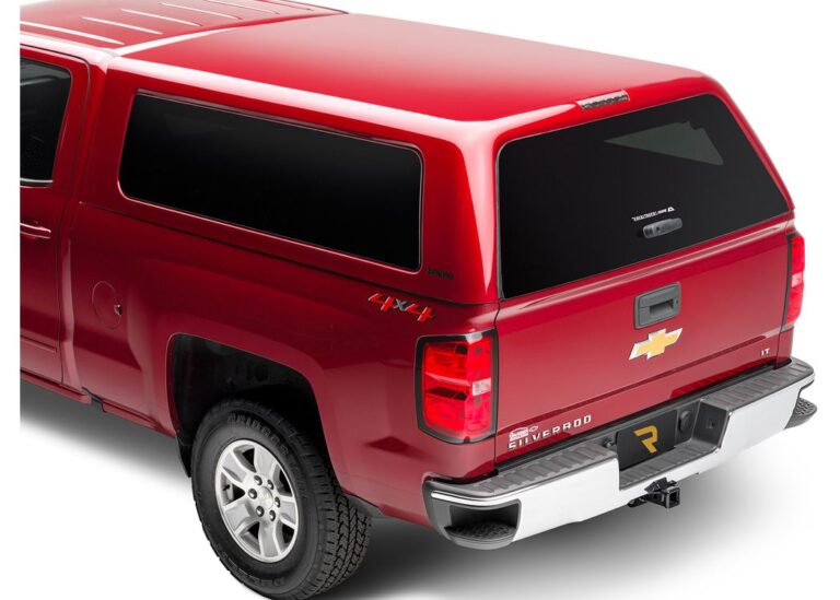Rear view of a red, paint-matched A.R.E. CX Revo truck cap with a frameless tailgate-formed rear door on a red Chevrolet Silverado