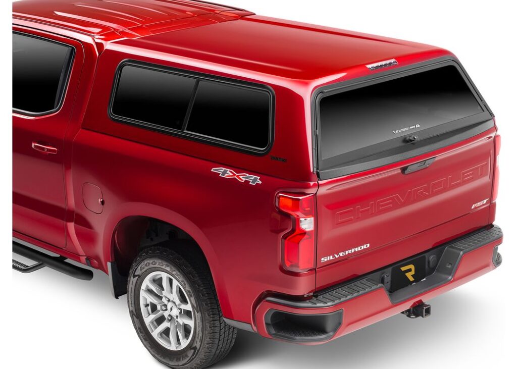 Rear view of a red, paint-matched A.R.E. V Series fiberglass truck cap on a red Chevrolet Silverado