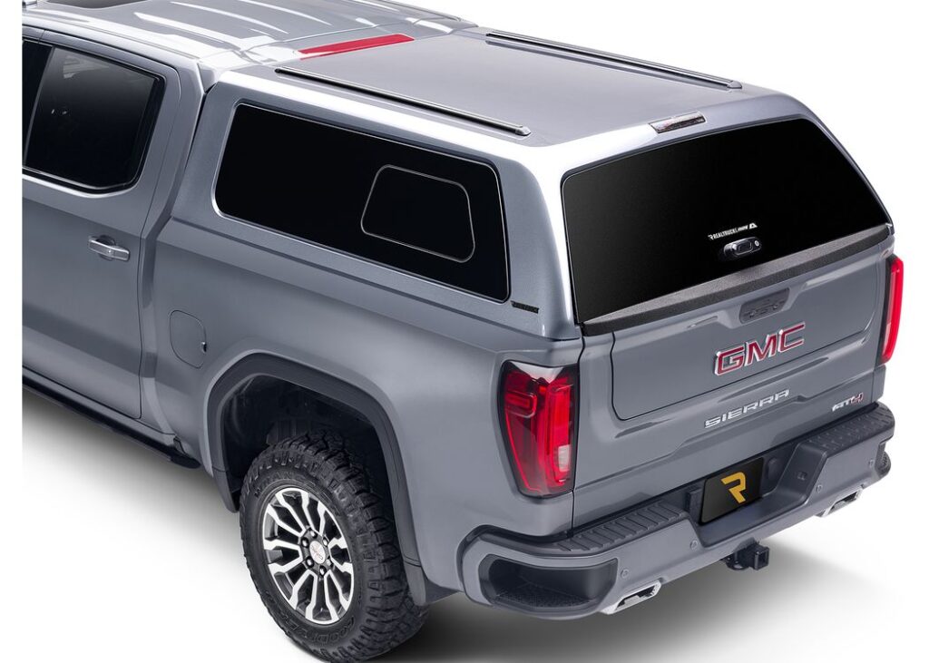 Rear view of a gray A.R.E. Z2 Series truck cap with bonded frameless glass on a matching gray GMC Sierra