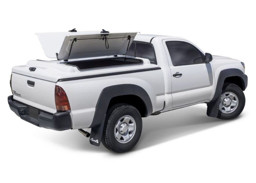 A.R.E. 3DL fiberglass tonneau cover with its lid raised on a white Toyota Tacoma