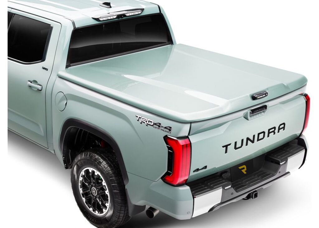 Paint-matched A.R.E. LS3 one-piece hinged tonneau cover, closed, on a sage green Toyota Tundra