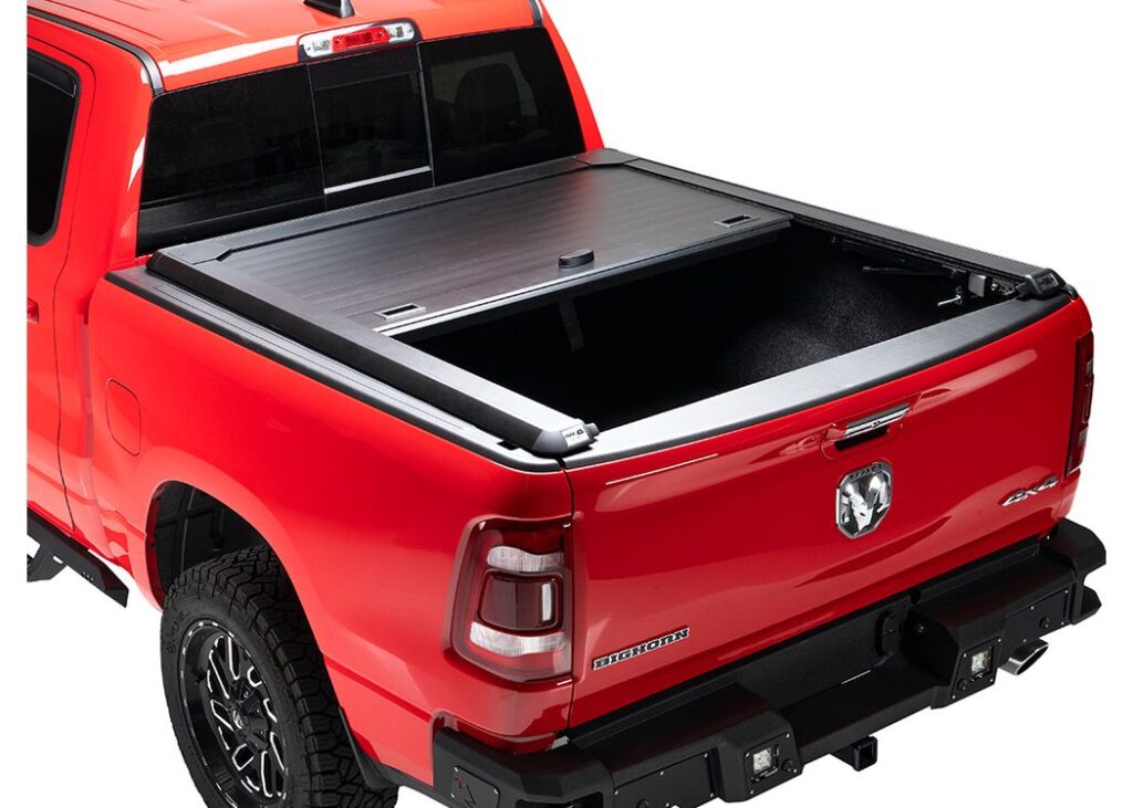A.R.E. DoubleCover aluminum tonneau cover partly retracted on a red Ram 1500