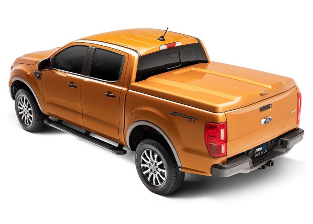 Paint-matched A.R.E. LSII fiberglass tonneau cover, closed, on an orange Ford Ranger